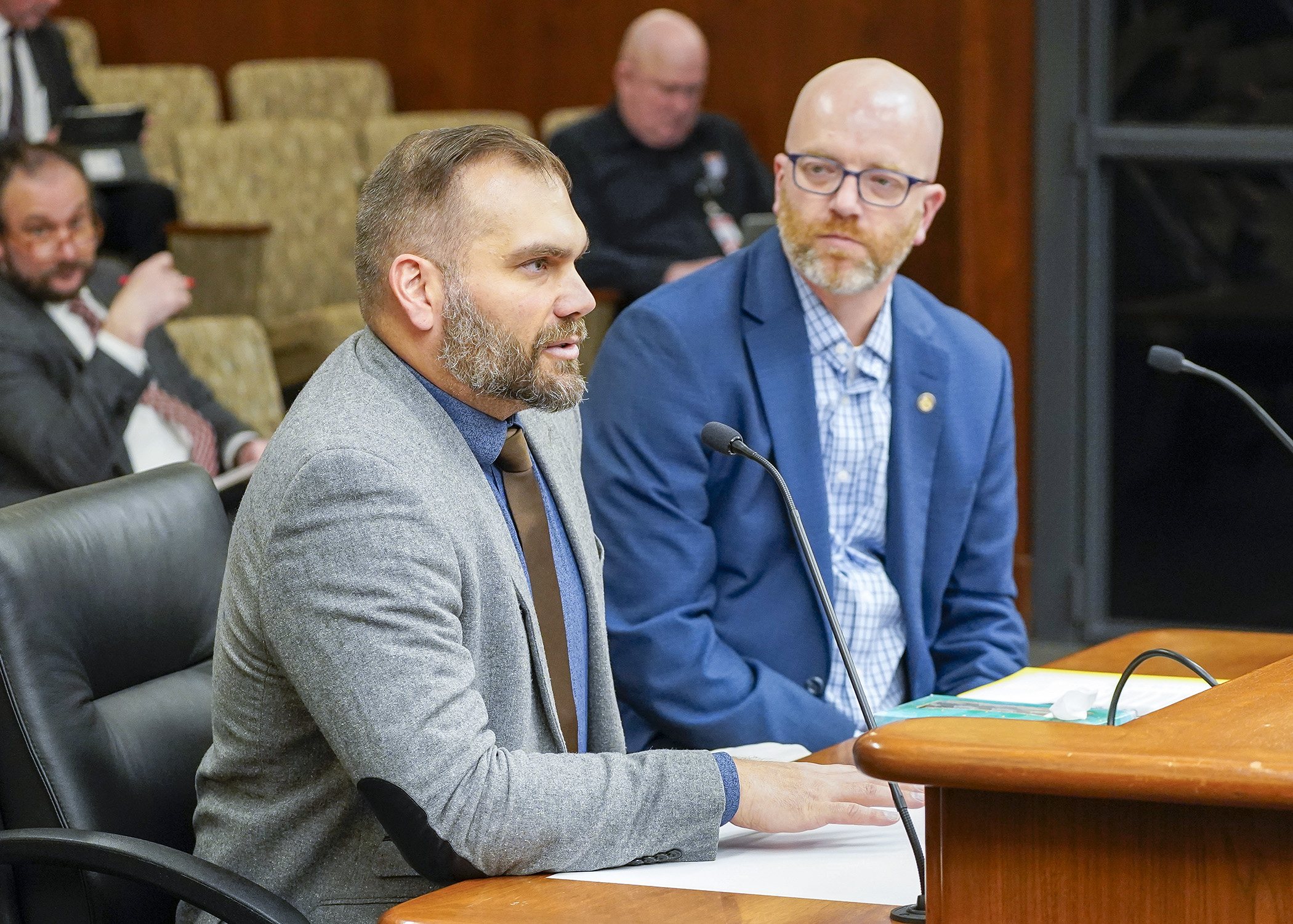 Steve Huser, government relations representative for the City of Minneapolis, testifies before the House Commerce Finance and Policy Committee in support of a bill that’d require motor vehicle manufacturers to offer antitheft protection devices on vehicles. Rep. Brad Tabke, right, is the bill sponsor. (Photo by Andrew VonBank)